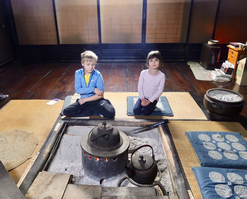 Kids getting cosy around the fire pit in the centre of the ground floor. The whole house is a bit smokey